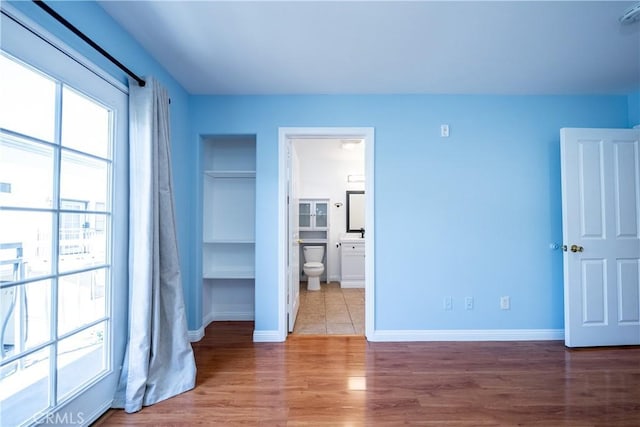 10894 Olinda St Unit 116, Sun Valley, CA 91352 - unfurnished bedroom with multiple windows, wood finished floors, and baseboards