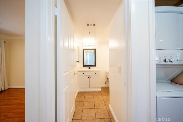 10894 Olinda St Unit 116, Sun Valley, CA 91352 - corridor featuring estacked washer and dryer, baseboards, light tile patterned flooring, ornamental molding, and a sink
