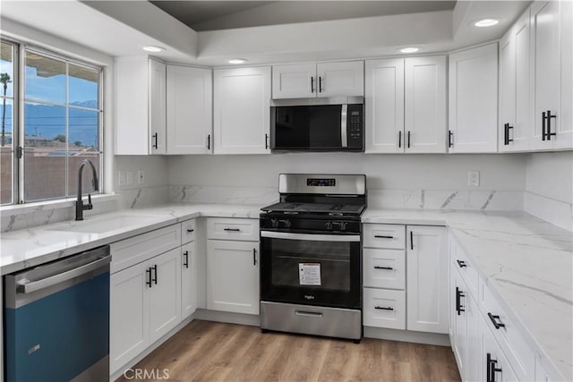 13565 Monterey Rd, Desert Hot Springs, CA 92240 - kitchen with appliances with stainless steel finishes, a sink, white cabinets, recessed lighting, and light wood-style floors