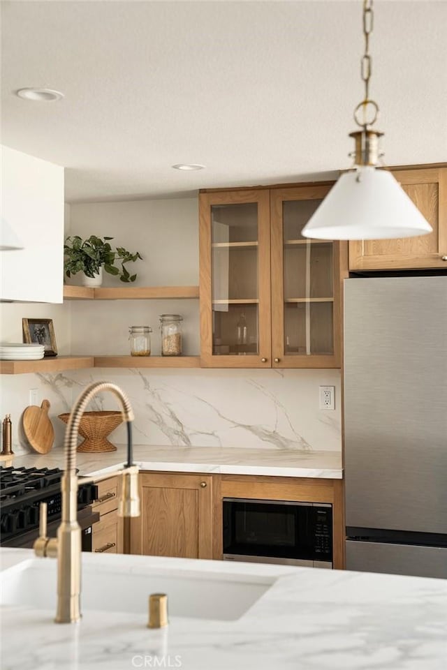13 Lucero W, Irvine, CA 92620 - kitchen with freestanding refrigerator, black microwave, brown cabinets, a sink, and open shelves