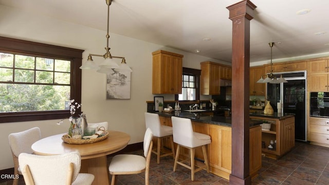 1813 Wayne Ave, South Pasadena, CA 91030 - kitchen with black appliances, dark countertops, a peninsula, decorative light fixtures, and dark stone finish flooring