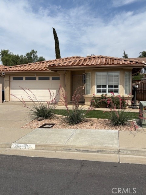 28056 Calle Vallarta, Menifee, CA 92585 - view of front of property with a garage, driveway, stucco siding, and a tiled roof