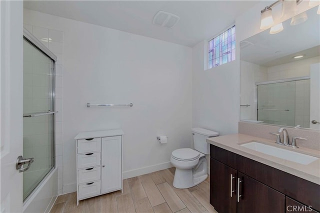 9213 Sunshine Pl, Downey, CA 90240 - bathroom with vanity, toilet, wood finished floors, bath / shower combo with glass door, and baseboards