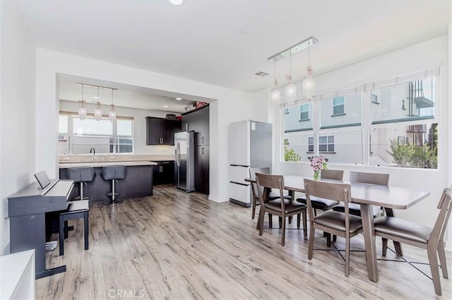 9213 Sunshine Pl, Downey, CA 90240 - dining space featuring light wood-style flooring and baseboards