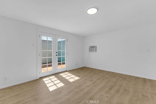 6365 Cahuilla Ave Unit 29, Palms, CA 92277 - empty room with french doors, light wood-style floors, a wall mounted air conditioner, and baseboards