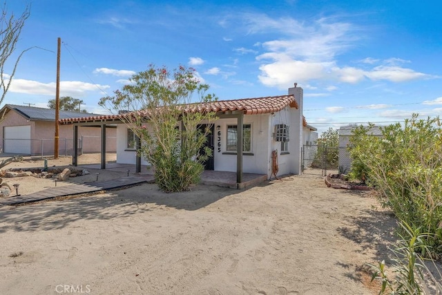 6365 Cahuilla Ave Unit 29, Palms, CA 92277 - view of front facade with a tile roof, stucco siding, and a chimney