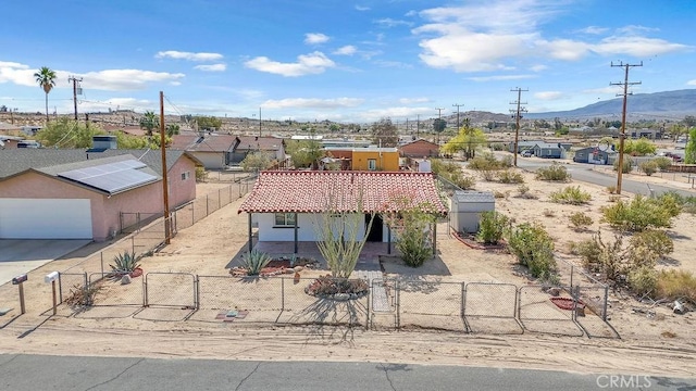 6365 Cahuilla Ave Unit 29, Palms, CA 92277 - view of front facade featuring a gate, a fenced front yard, a garage, and a mountain view