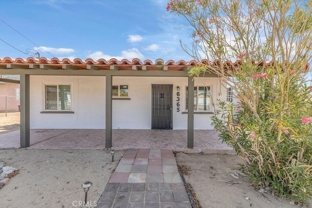 6365 Cahuilla Ave Unit 29, Palms, CA 92277 - mediterranean / spanish-style house with stucco siding, a tiled roof, and covered porch