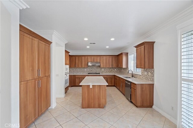 5840 Redhaven St, Eastvale, CA 92880 - kitchen with under cabinet range hood, white appliances, tasteful backsplash, a sink, and a kitchen island