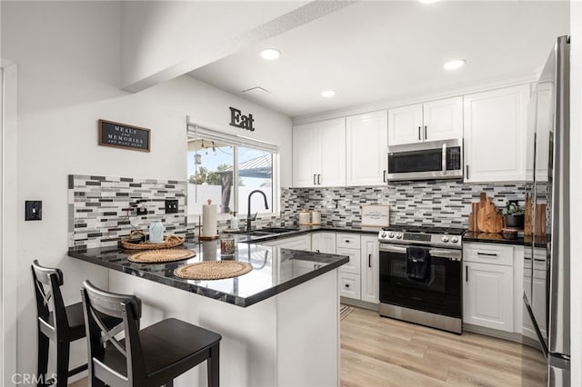 1138 Millstream Ln, Corona, CA 92878 - kitchen with appliances with stainless steel finishes, a sink, a peninsula, white cabinets, and recessed lighting