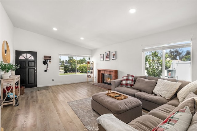 1138 Millstream Ln, Corona, CA 92878 - living room with healthy amount of natural light, lofted ceiling, recessed lighting, a fireplace, and light wood-style floors
