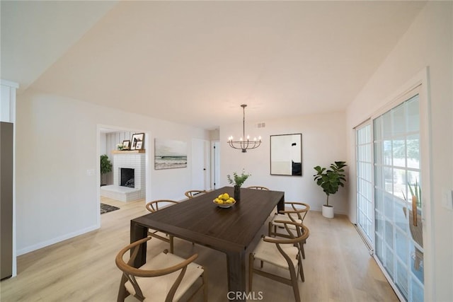 25810 San Felipe Dr, Hemet, CA 92544 - dining room featuring light wood-style flooring, baseboards, a chandelier, and a fireplace
