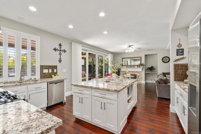 8550 Alexandria St, Riverside, CA 92508 - kitchen with stainless steel dishwasher, tasteful backsplash, open floor plan, white cabinetry, and ceiling fan