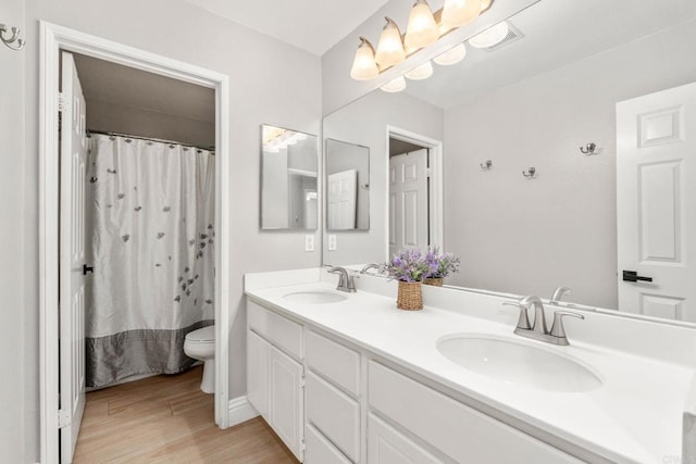 8550 Alexandria St, Riverside, CA 92508 - bathroom featuring toilet, wood finished floors, double vanity, and curtained shower