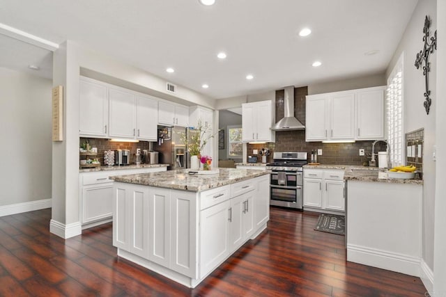 8550 Alexandria St, Riverside, CA 92508 - kitchen featuring stainless steel appliances, wall chimney exhaust hood, baseboards, tasteful backsplash, and a kitchen island