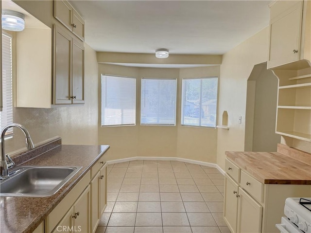 812 Wilson Ave, Bakersfield, CA 93308 - kitchen featuring butcher block countertops, a sink, baseboards, and light tile patterned floors
