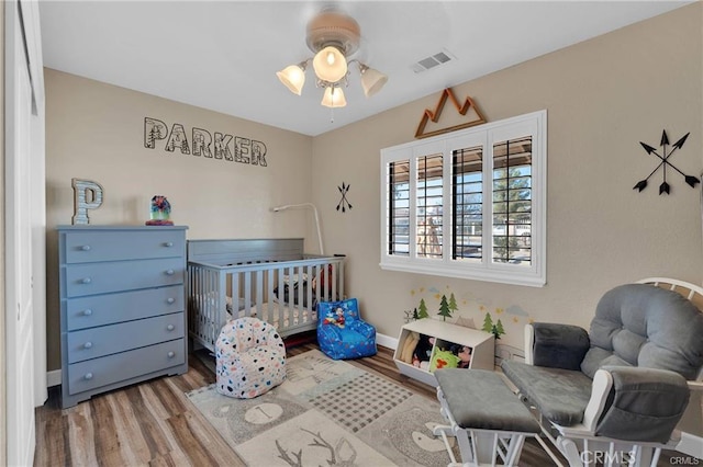 19055 Seaforth St, Hesperia, CA 92345 - bedroom featuring wood finished floors, baseboards, and a nursery area