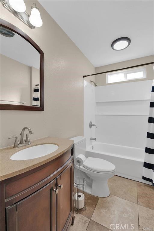 19055 Seaforth St, Hesperia, CA 92345 - bathroom featuring vanity, toilet, and shower / bathtub combination with curtain