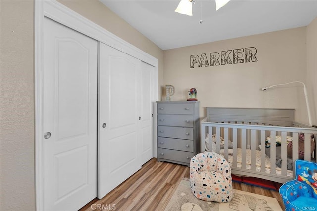 19055 Seaforth St, Hesperia, CA 92345 - bedroom featuring a closet, wood finished floors, a crib, and ceiling fan