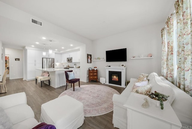 3001 Bravo Loop Unit 1, Chula Vista, CA 91915 - living area featuring wood finished floors, recessed lighting, a glass covered fireplace, and baseboards
