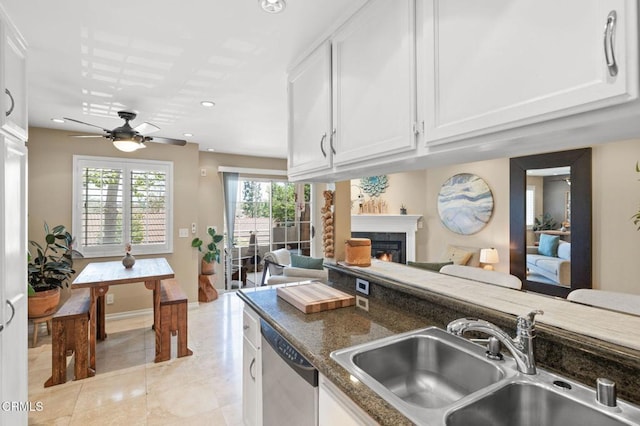 2623 Antonio Dr Unit 104, Camarillo, CA 93010 - kitchen featuring a sink, dishwasher, a lit fireplace, ceiling fan, and white cabinets