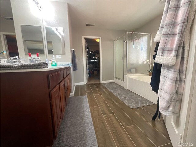 31728 Pompei Ln, Winchester, CA 92596 - bathroom featuring vanity, a shower stall, wood tiled floors, a garden tub, and a walk in closet