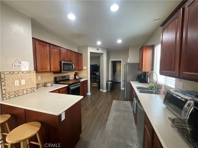 31728 Pompei Ln, Winchester, CA 92596 - kitchen with stainless steel appliances, a sink, tasteful backsplash, a breakfast bar, and light countertops
