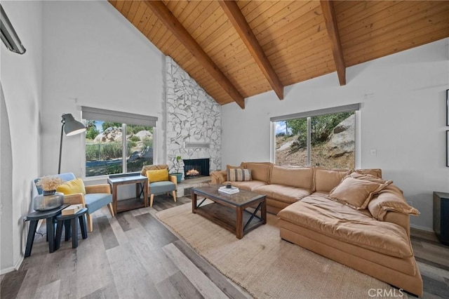40901 Gibbel Rd, Hemet, CA 92544 - living area featuring wood finished floors, a stone fireplace, wooden ceiling with exposed beams, high vaulted ceiling, and baseboards