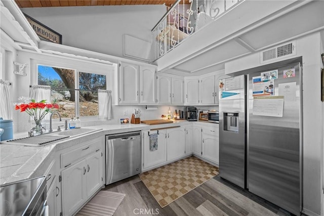 40901 Gibbel Rd, Hemet, CA 92544 - kitchen with appliances with stainless steel finishes, white cabinets, light wood-type flooring, a sink, and lofted ceiling