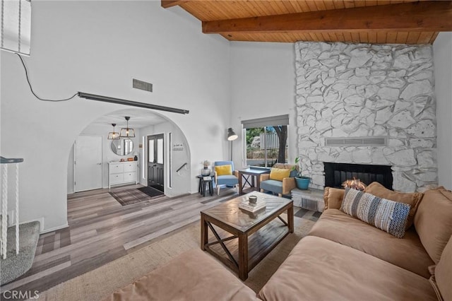40901 Gibbel Rd, Hemet, CA 92544 - living room with arched walkways, a fireplace, wooden ceiling with exposed beams, wood finished floors, and a chandelier
