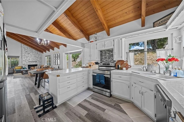 40901 Gibbel Rd, Hemet, CA 92544 - kitchen with stainless steel appliances, a peninsula, wood ceiling with exposed beams, white cabinets, and light wood-style flooring