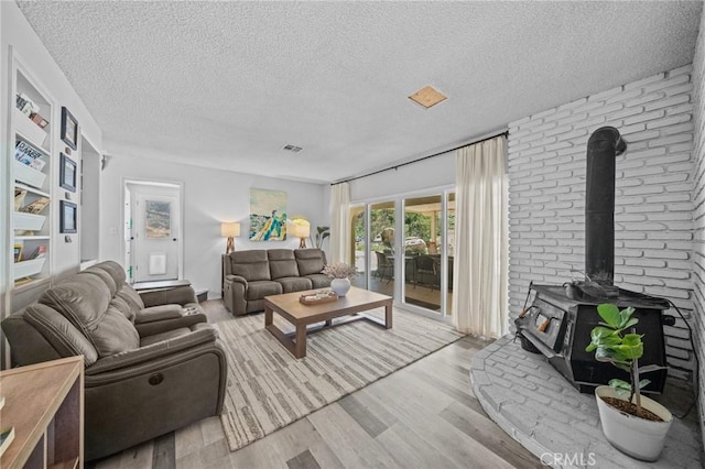 40901 Gibbel Rd, Hemet, CA 92544 - living room featuring a wood stove, wood finished floors, and a textured ceiling