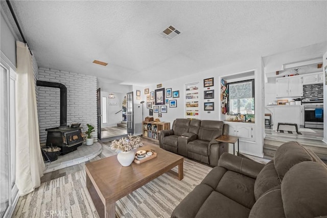40901 Gibbel Rd, Hemet, CA 92544 - living room featuring a wood stove, a textured ceiling, and light wood finished floors