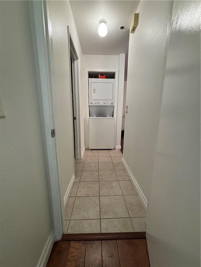 3513 Caminito Sierra Unit 101, Carlsbad, CA 92009 - corridor with stacked washing machine and dryer, baseboards, and light tile patterned floors