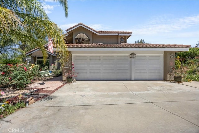 10750 Orchard View Ln, Riverside, CA 92503 - mediterranean / spanish-style home featuring driveway, stucco siding, a tiled roof, and a garage