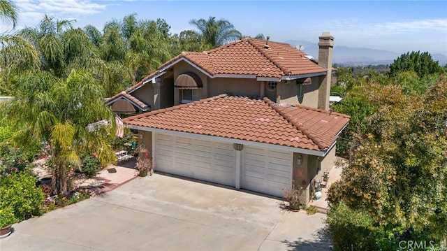 10750 Orchard View Ln, Riverside, CA 92503 - mediterranean / spanish-style home featuring a tile roof, concrete driveway, stucco siding, and a garage