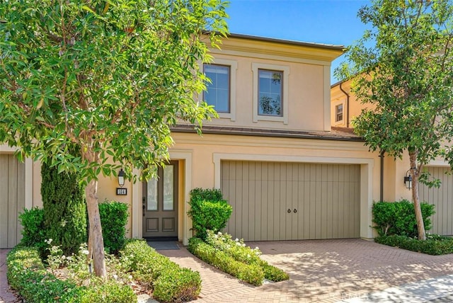 104 Working, Irvine, CA 92602 - townhome / multi-family property featuring decorative driveway, stucco siding, and an attached garage