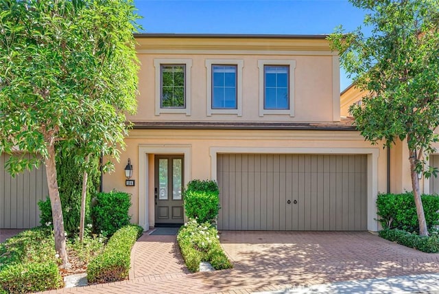 104 Working, Irvine, CA 92602 - view of property featuring decorative driveway, stucco siding, and a garage