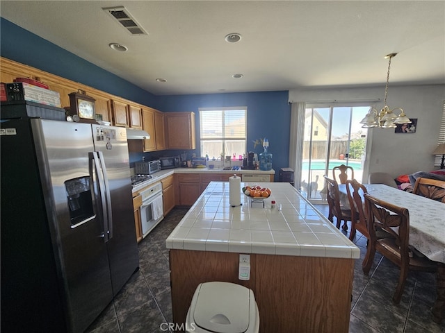 12912 Newport St, Hesperia, CA 92344 - kitchen featuring stainless steel appliances, a center island, tile counters, a chandelier, and dark tile patterned flooring