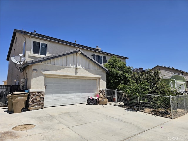12912 Newport St, Hesperia, CA 92344 - traditional home featuring board and batten siding, driveway, an attached garage, stone siding, and stucco siding