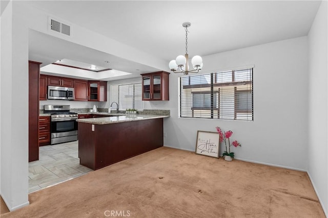 17117 S Vermont Ave Unit 132, Gardena, CA 90247 - kitchen with appliances with stainless steel finishes, a peninsula, a chandelier, a sink, and glass insert cabinets