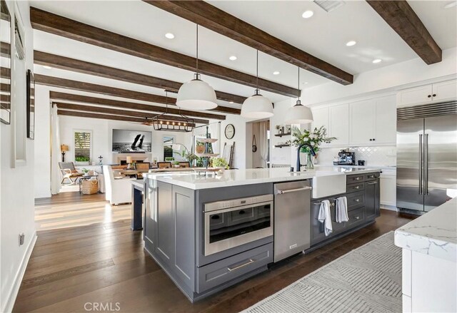 101 Via Almodovar, San Clemente, CA 92672 - kitchen with appliances with stainless steel finishes, decorative backsplash, a spacious island, dark wood-style floors, and white cabinets