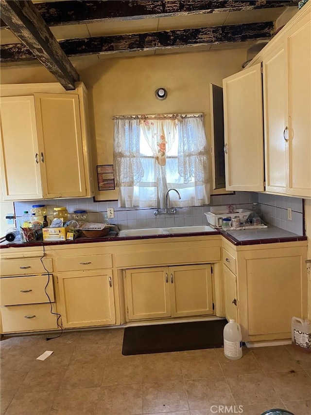 1713 W 165th St, Compton, CA 90220 - kitchen with tile countertops, a sink, tasteful backsplash, beam ceiling, and white cabinets