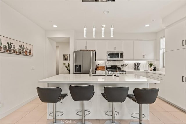 80281 Redstone Way, La Quinta, CA 92253 - kitchen featuring appliances with stainless steel finishes, a kitchen bar, light countertops, white cabinetry, and recessed lighting