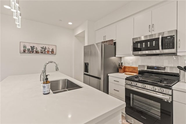 80281 Redstone Way, La Quinta, CA 92253 - kitchen featuring appliances with stainless steel finishes, a sink, light countertops, white cabinets, and backsplash