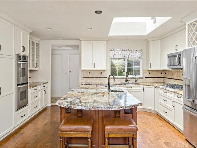 1051 La Reina, San Marcos, CA 92078 - kitchen featuring stainless steel appliances, wood finished floors, a sink, white cabinets, and recessed lighting