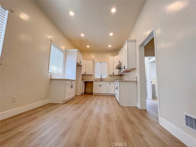 1051 W 18th St, Los Angeles, CA 90015 - kitchen with baseboards, light wood-style flooring, white cabinetry, a sink, and recessed lighting