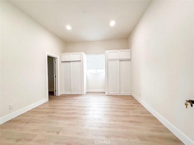 1051 W 18th St, Los Angeles, CA 90015 - unfurnished bedroom with baseboards, recessed lighting, light wood-style flooring, and two closets