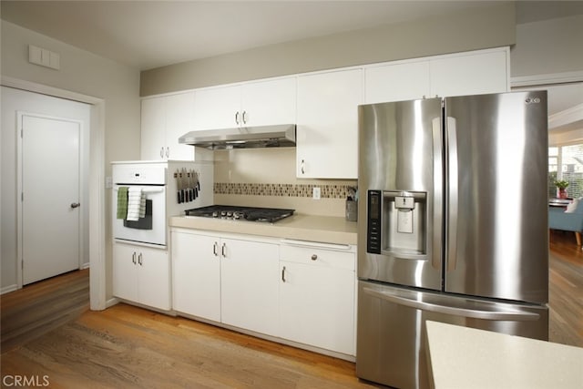 7235 Estepa Dr, Tujunga, CA 91042 - kitchen featuring stainless steel appliances, under cabinet range hood, light countertops, tasteful backsplash, and light wood-style flooring