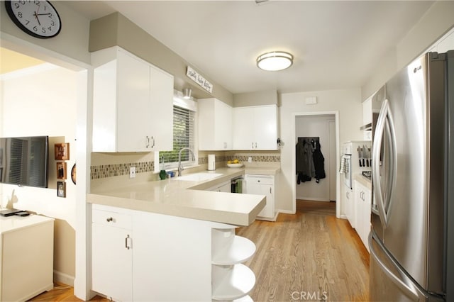 7235 Estepa Dr, Tujunga, CA 91042 - kitchen featuring freestanding refrigerator, a sink, a peninsula, light countertops, and white cabinetry